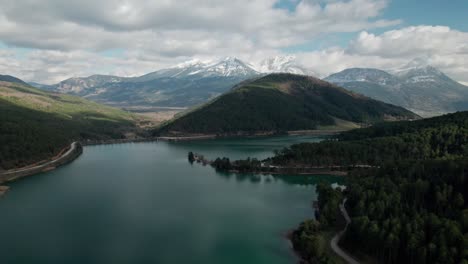 Aerial-Establishing-Shot,-Lake-Doxa-Mountainous-Landscape,-Calm-Blue-Greek-Waters-surrounded-by-Dreamlike-Hills-of-Pine-Forest