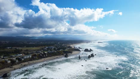 Beautiful-4K-aerial-drone-shot-overseeing-ocean-landscape-and-blue-sky-with-clouds-in-Bandon,-Oregon