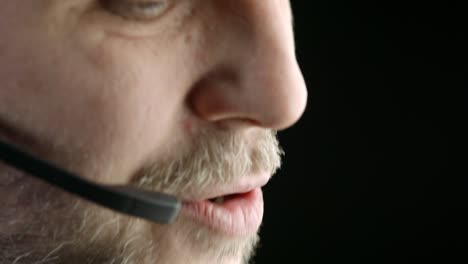 Face-closeup:-Man-shakes-head-while-speaking-into-telephone-head-set