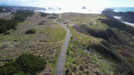 Stunning-4K-aerial-drone-shot-showcasing-pedestrian-walking-on-path-overlooking-Pacific-Northwest-ocean