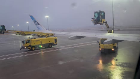 Ala-De-Aeronave-Fronteriza,-N344fr,-Se-Descongela-Luego-De-Una-Tormenta-Helada-En-Dtw-Vista-Desde-El-Interior-De-La-Aeronave-Que-Termina-Con-Salpicaduras-De-Líquido-Descongelador-En-La-Ventana-De-Visualización