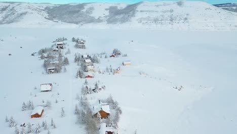 An-eagle-eye-drone-shot-of-the-Snow-Covered-Mountains-and-houses-in-villages-in-the-Perfect-Winter-Escape-in-Park-City,-Utah