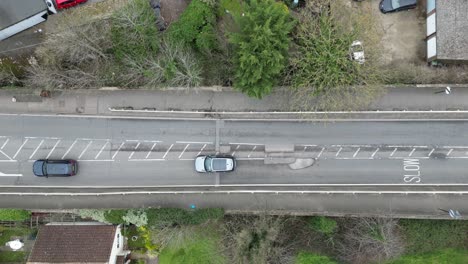 Vehicles-slowly-driving-around-large-pothole-UK-croad-overhead-birds-eye-view-drone-aerial
