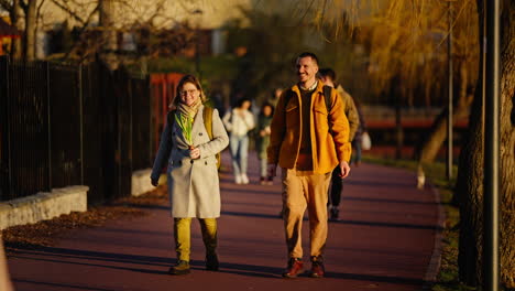 Working-couple-walking-together-in-the-park-in-slow-motion-while-smiling-and-laughing