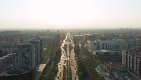 Aerial-pedestal-shot-lowering-between-two-busy-lanes-of-a-highway-in-Zagreb,-Croatia-late-in-the-afternoon