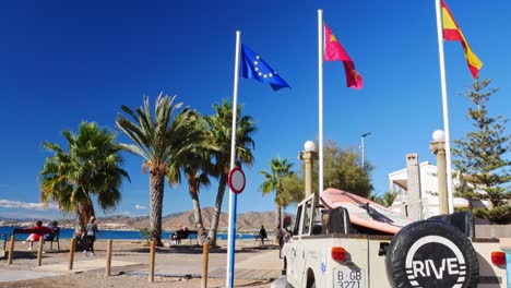 Flaggen-Und-Alter-Landrover-Am-Strand-Von-La-Azohía,-Murcia,-Spanien
