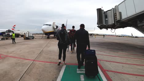 Passengers-walking-towards-Ryanair-aircraft-to-board-at-Brussels-Zaventem-International-Airport---Back-view-following-shot
