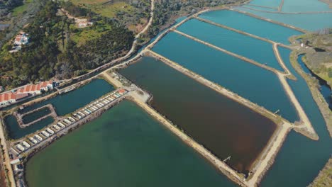 Disused-discolored-fish-farm-pool-titling-aerial-shot