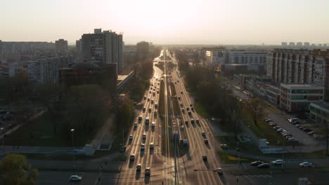 Vehicles-Driving-Over-Highway-In-Suburbs-Zagreb,-Croatia-At-Sunset---aerial-drone-shot