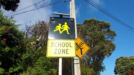 Precaución-Señal-De-Tráfico-De-La-Zona-Escolar-Con-El-Símbolo-De-Padre-E-Hijo-En-Nueva-Zelanda-Aotearoa