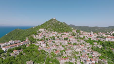 Aerial-arcing-shot-gently-circling-around-the-town-of-Lastovo,-Croatia-on-a-bright-clear-day