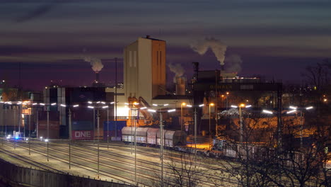 Time-Lapse-of-Industrial-Berlin-Westhafen-Station-With-Freight-Trains-on-Tracks-and-Working-Factories,-Exhausted-Humes-and-CO2-Atmospheric-Emissions-in-Berlin