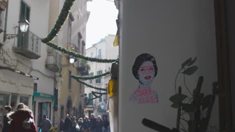 Amalfi-Kunst-Einer-Frau,-Die-Mit-Vorbeigehenden-Menschen-Auf-Die-Straße-Schwenkt