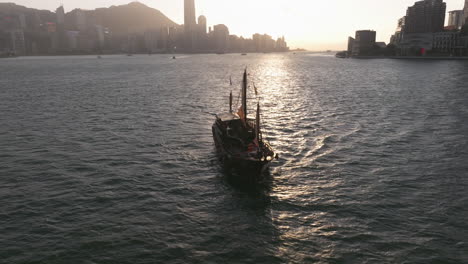 Backwards-dolley-tilt-shot-of-Aqua-Luna-junk-boat-replica-in-Victoria-Harbour