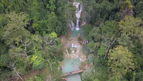 Aerial-flyover-of-tourists-visiting-popular-Kuang-Si-Waterfall-in-Laos