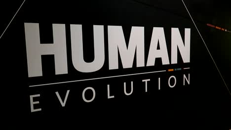 Weißes-Buchstabenschild-Der-Menschlichen-Evolution-Auf-Schwarzem-Hintergrund,-Naturkundemuseum
