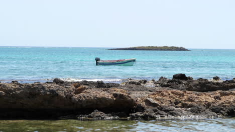 Kleines-Fischermotorboot-Im-Blauen-Wasser-Des-Strandes-Von-Elafonissi,-Griechenland