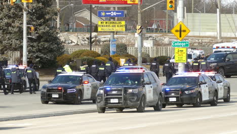 La-Policía-Camina-En-Una-Fila-Sobre-La-Carretera-Bloqueada-Por-Los-Manifestantes,-Los-Partidarios-Del-Convoy-De-La-Libertad-En-Windsor,-Canadá