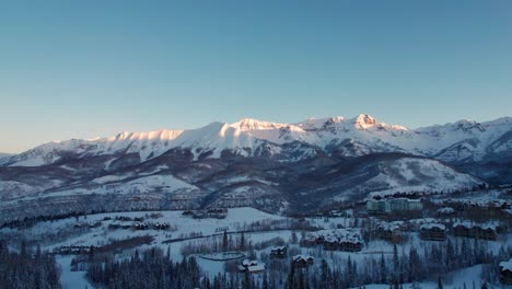 Drone-aerial-view-of-the-sunrise-hitting-the-peaks-outside-of-Telluride,-CO