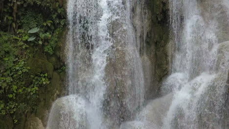 Full-frame-rising-crane-shot-of-tiered-Kuang-Si-Waterfall,-rural-Laos