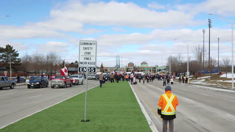 Caminando-Hacia-La-Multitud-De-Manifestantes-En-La-Calle-En-Windsor,-Canadá-Durante-La-Manifestación-Del-Convoy-De-Camioneros-Contra-La-Vacunación-Obligatoria