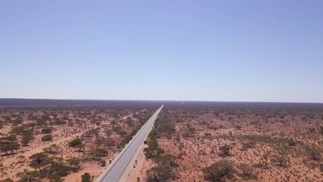 Aerial-Shot-of-a-Car-Making-its-Way-through-the-Outback-along-Stuart-Highway,-Australia