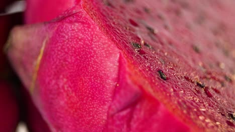 Rotierende-Zeitlupenaufnahme-Einer-In-Zwei-Hälften-Geschnittenen-Drachenfrucht,-Die-Ihr-Saftiges-Inneres-Und-Ihre-Vielen-Samen-Enthüllt