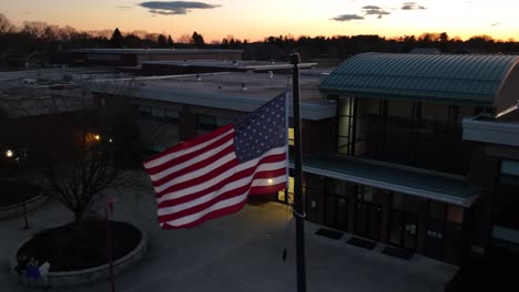 American-flag-waving-in-front-of-school-in-America-at-night