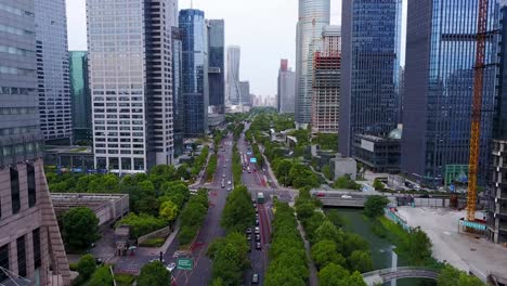 Aerial-Shot-of-Downtown-Traffic-along-the-River-between-Skyscrapers-in-Hangzhou,-China