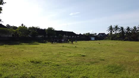 Balinesische-Kinder-üben-Fußball-Und-Sport-Auf-Einer-Grünen-Wiese-In-Ubud-Bei-Tageslicht,-Bali,-Indonesien,-Lustige-Kindheit