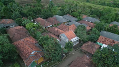 Aerial-shot-of-Karawang,-Kutamaneuh-village-next-to-paddy-fields-during-a-cloudy-sunrise,-Bali,-Indonesia