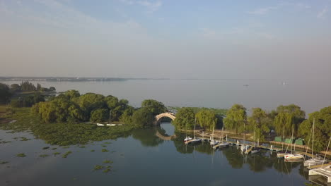 Fliegen-Sie-über-Das-Unkraut-Des-Jachthafens-Zur-Bogenbrücke,-Dem-Dianshan-See,-Shanghai,-China
