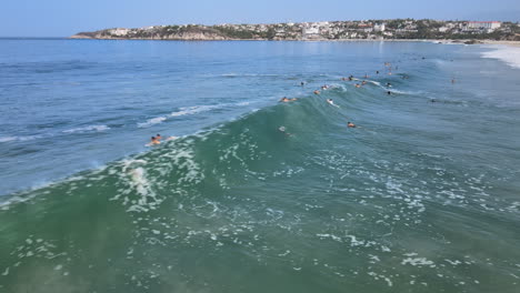 Muchos-Surfistas-Nadando-Hacia-Las-Olas-Del-Océano