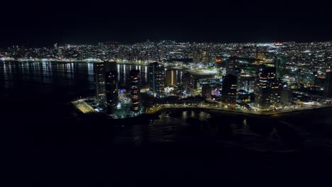 Aerial-rotating-shot-of-the-stunning-bright-lights-at-night-of-Iquique,-Chile