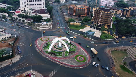 Drone-shot-overlooking-traffic-in-the-Prime-Ministerial-Roundabout-in-cloudy-Yaounde,-Cameroon