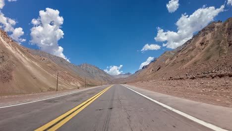 POV-shot-driving-through-the-dry-mountain-range-in-Mendoza,-Argentina