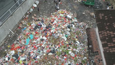 People-dump-trash-and-waste-in-a-landfill-in-Bali,-Denpasar,-Indonesia