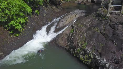 Indonesian-youth-slides-down-waterfall-slide-head-first-in-rural-Bali