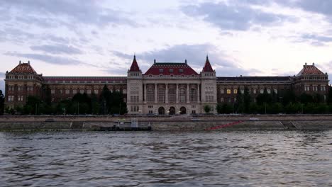 Edificio-De-La-Universidad-De-Tecnología-Y-Economía-De-Budapest-En-La-Hora-Dorada,-Disparado-Desde-El-Río-Danubio-En-Budapest,-Hungría