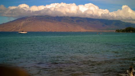 Hawaii-distant-boat-mountains-and-paddle-boarders-slow-motion