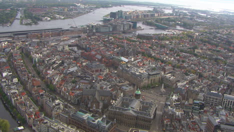 Rotating-helicopter-shot-of-downtown-Amsterdam-and-central-station,-Netherlands