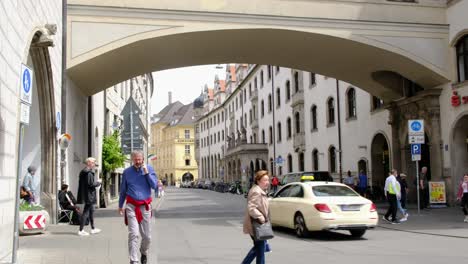 Vielbeschäftigte-Menschen-Gehen-Auf-Einer-Straße-Unter-Einer-Brücke-In-Der-Innenstadt-Von-Wien,-Österreich,-Vorbei
