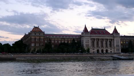 Cinematic-shot-of-Budapest-University-of-Technology-and-Economics-BME-building-at-golden-hour,-shot-from-the-Danube-River-in-Budapest,-Hungary