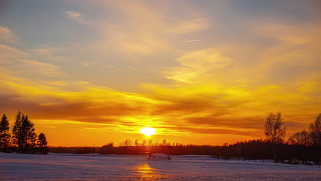 Vivid-golden-sunset-reflecting-in-icy-snow-landscape,-fusion-time-lapse