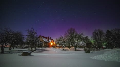 Northern-lights-or-aurora-borealis-glows-on-the-horizon-as-star-pass-over-a-cabin---time-lapse