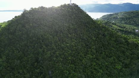 Ascenso-Aéreo-Sobre-Una-Exuberante-Selva-Tropical-Hasta-El-Faro-Con-Vista-Al-Océano,-Faro-De-Bote,-Catanduanes,-Filipinas