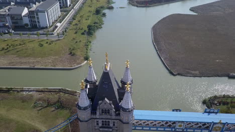 Aerial-looks-down-onto-ornate-turret-of-replica-London-bridge-in-China