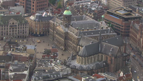 Aerial-zoom-out-shot-of-the-Dam-Square-in-downtown-Amsterdam,-Netherlands