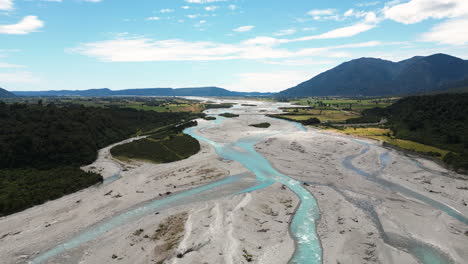 Almost-dried-out-vast-river-flowing-through-New-Zealand-landscape,-aerial-view