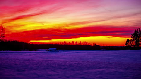 Wunderschöner-Orangefarbener-Sonnenuntergang-über-Einem-Verschneiten-Feld-Mit-Einem-Himmel,-Der-Aufgrund-Der-Leuchtenden-Farben-In-Flammen-Zu-Stehen-Scheint